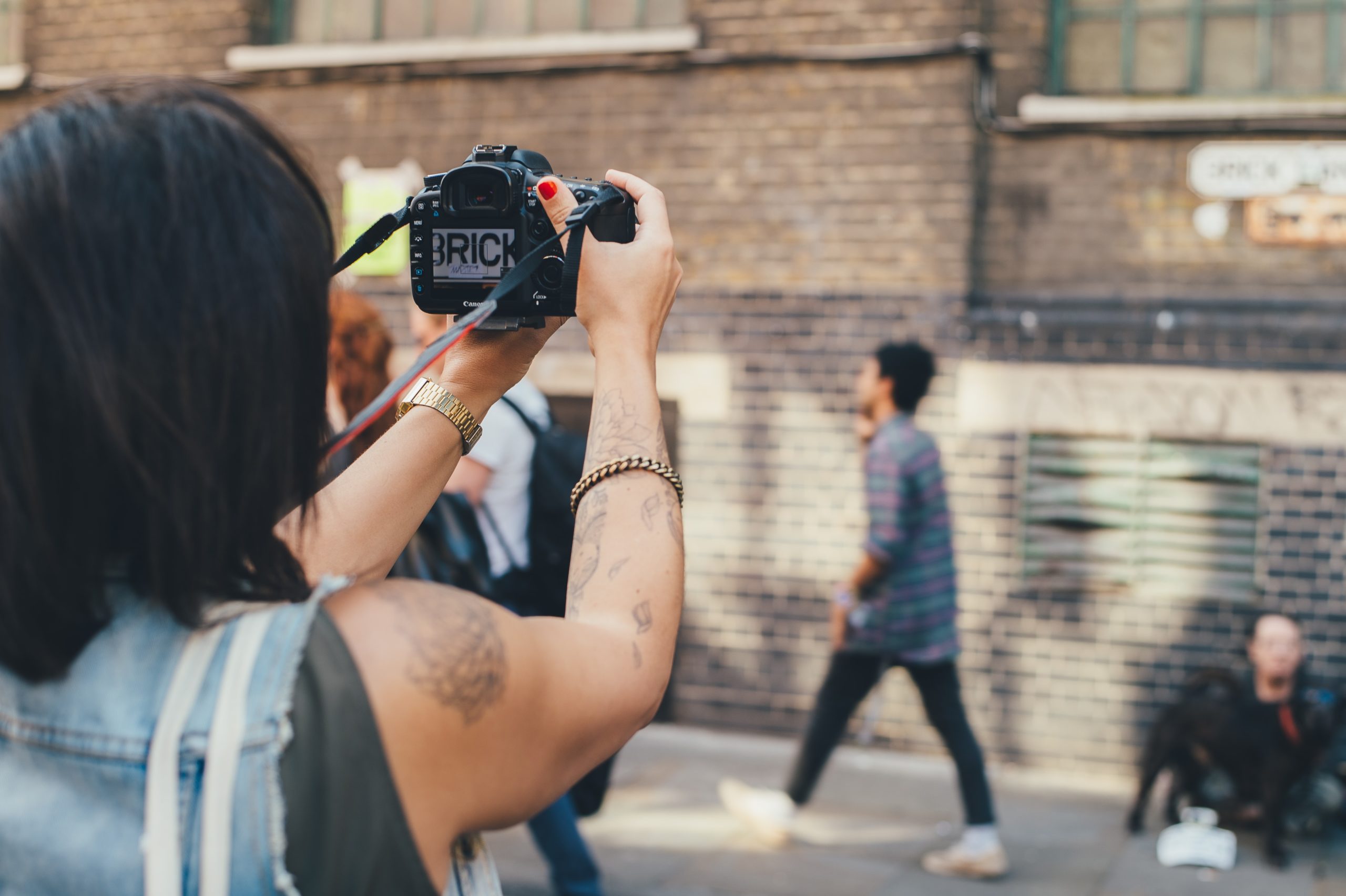 Photo d'une jeune femme en train de faire la photo d'une inscription sur un mur