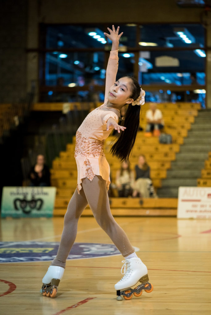 Photo couleur d'une patineuse en salle sur son final